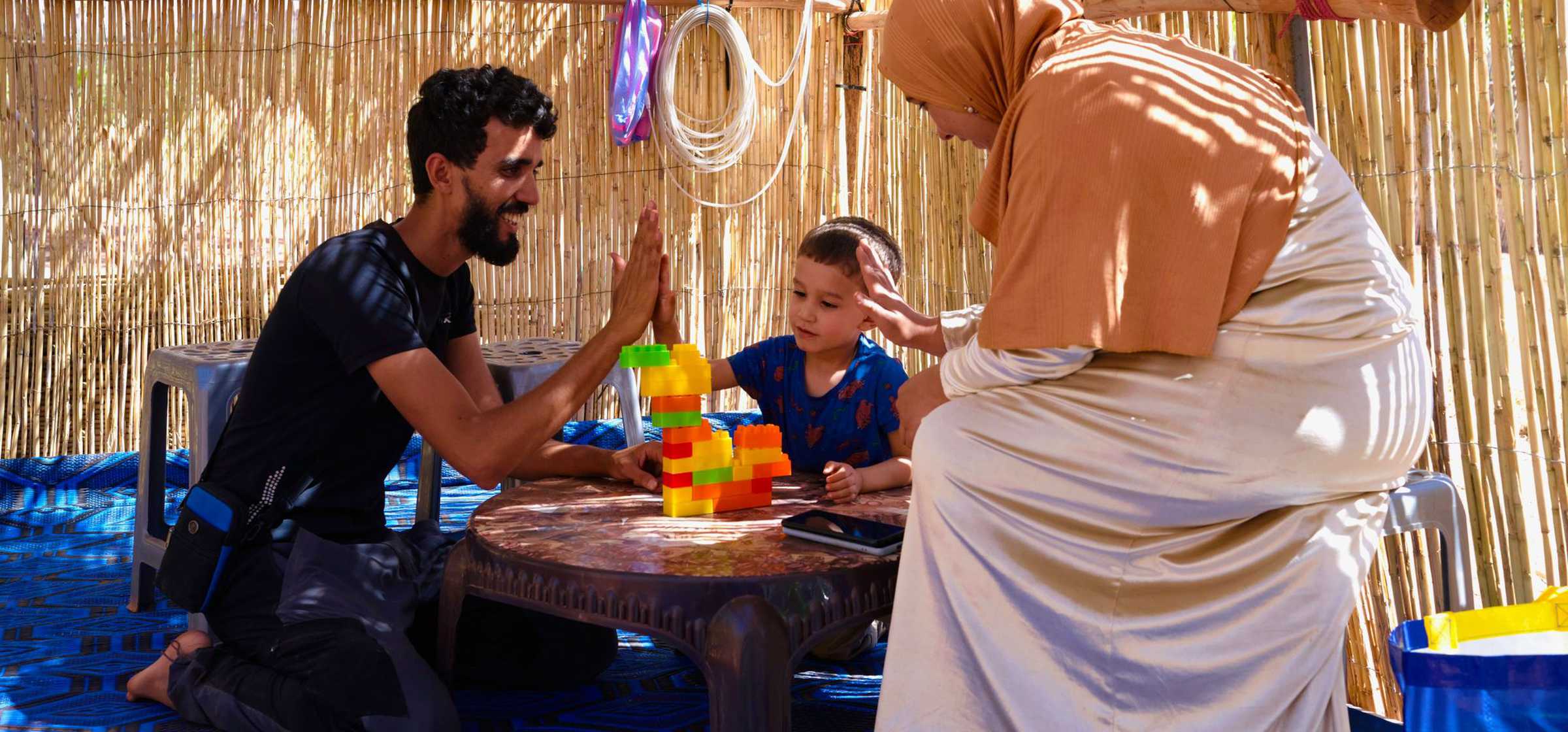 Mustafa the local teacher with child and mother in the Kindergarten REACT built today 01.jpeg